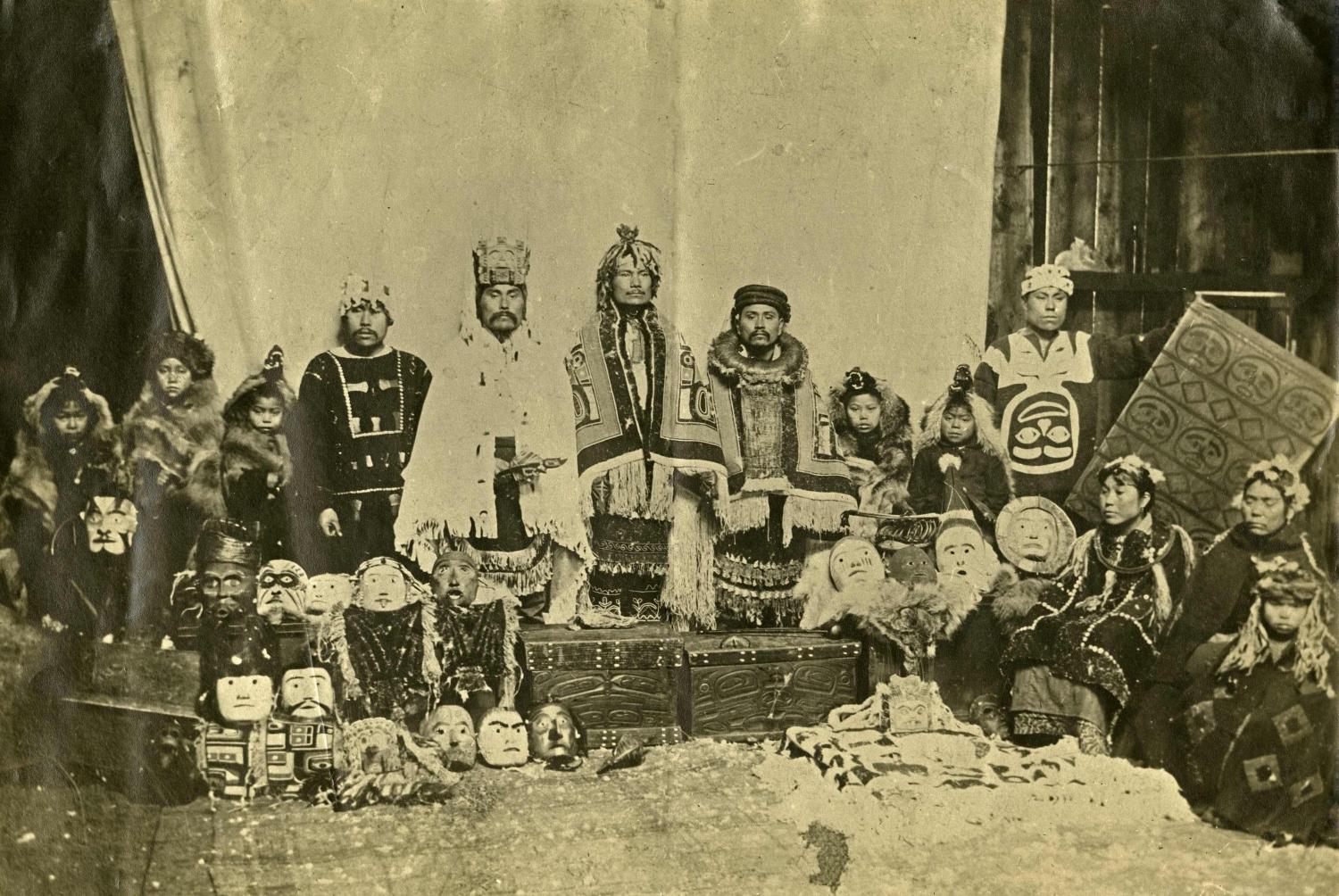 Nisga'a chiefs and families posing with goods from potlatch in 1903.