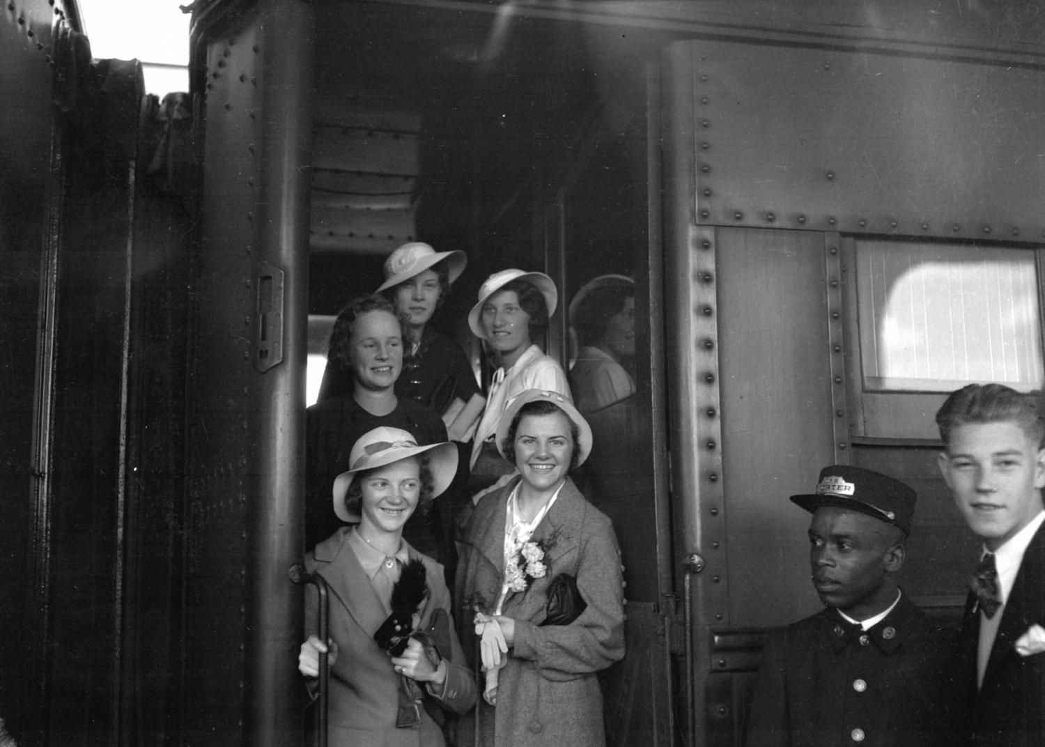 A C.N.R. porter stands by as passengers board a train in Vancouver in 1934.