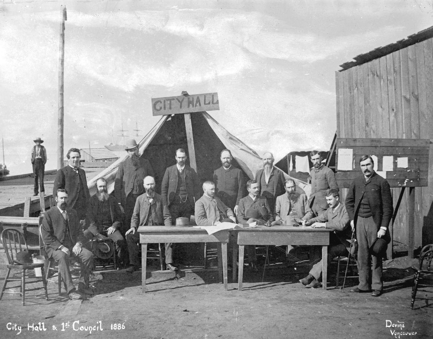 "Photograph shows City Council members and officials standing in front of a tent with the sign "City Hall", after the fire of 1886." 