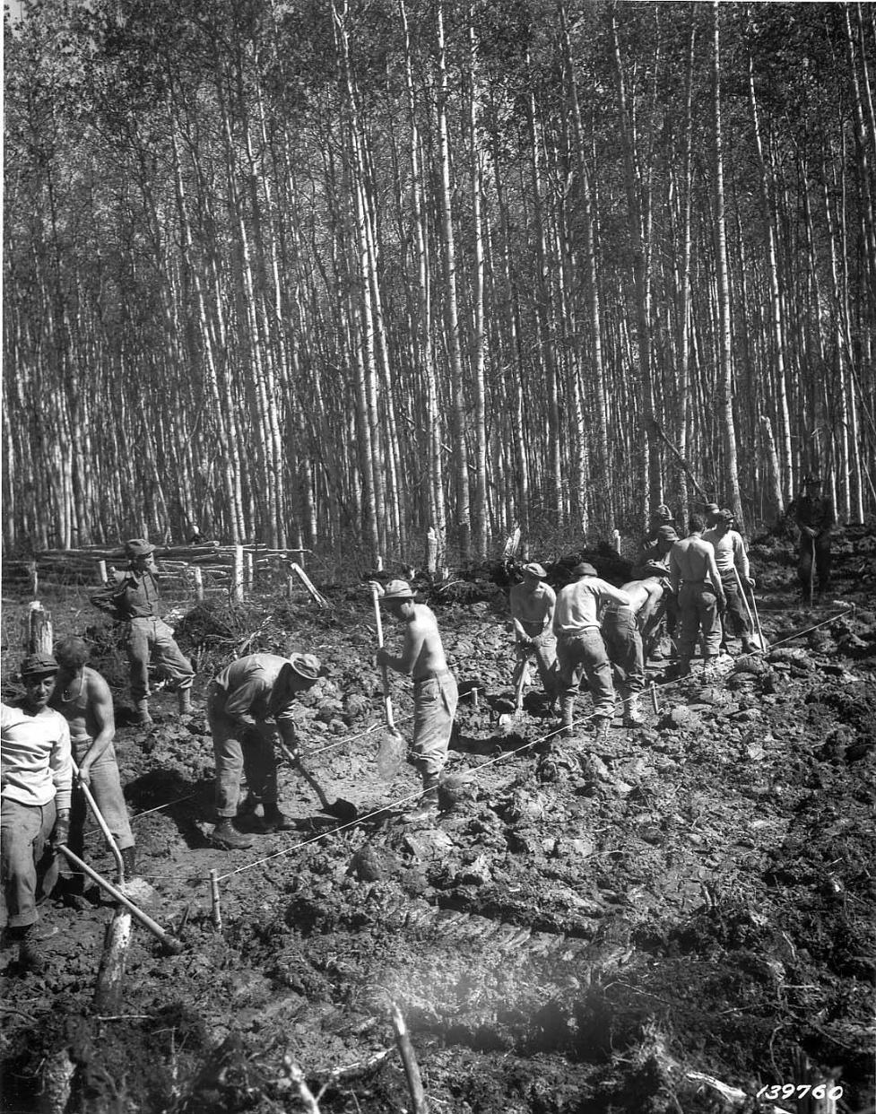 Men excavating ground for ALCAN Highway with hand shovels, circa 1942-43.