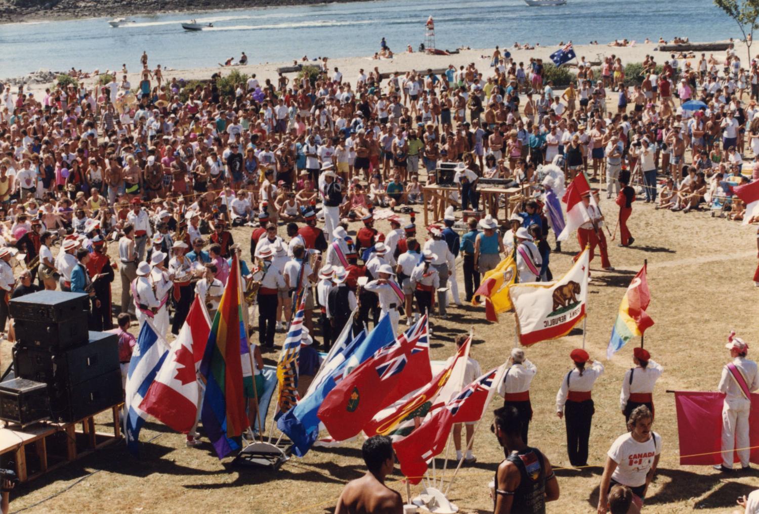 Crowd at beach with flags from different states and provinces