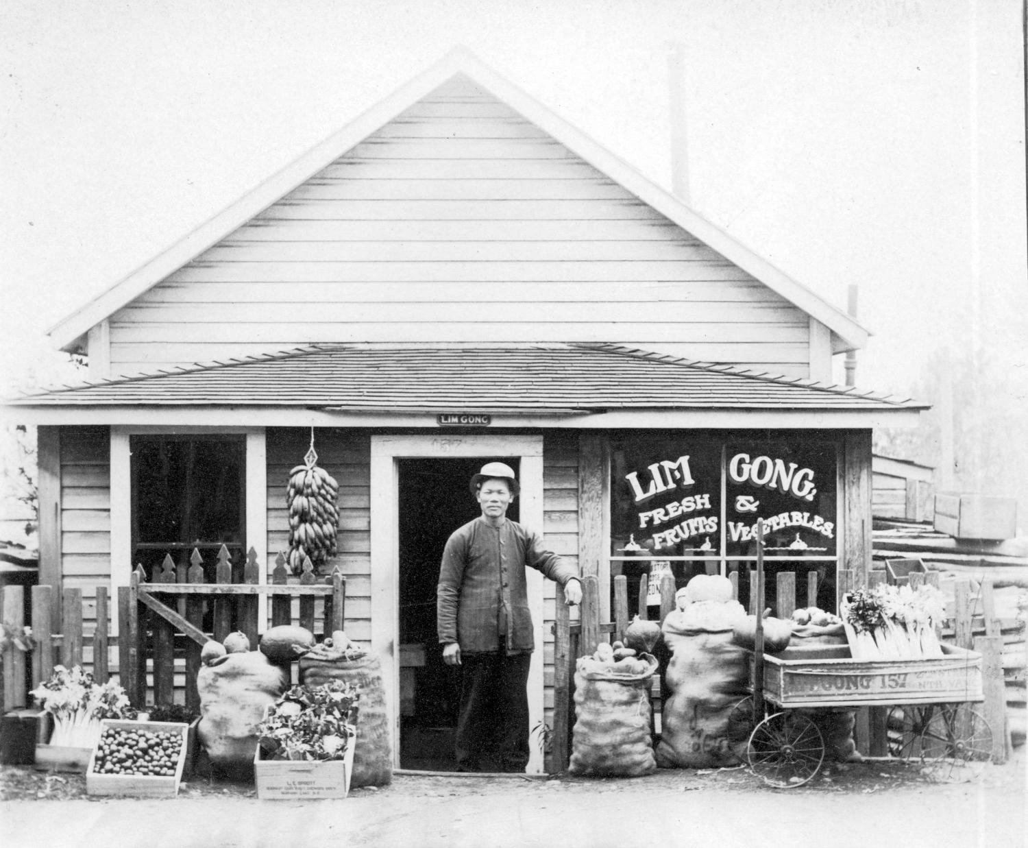 Lim Gong in front of his produce store in 1910.