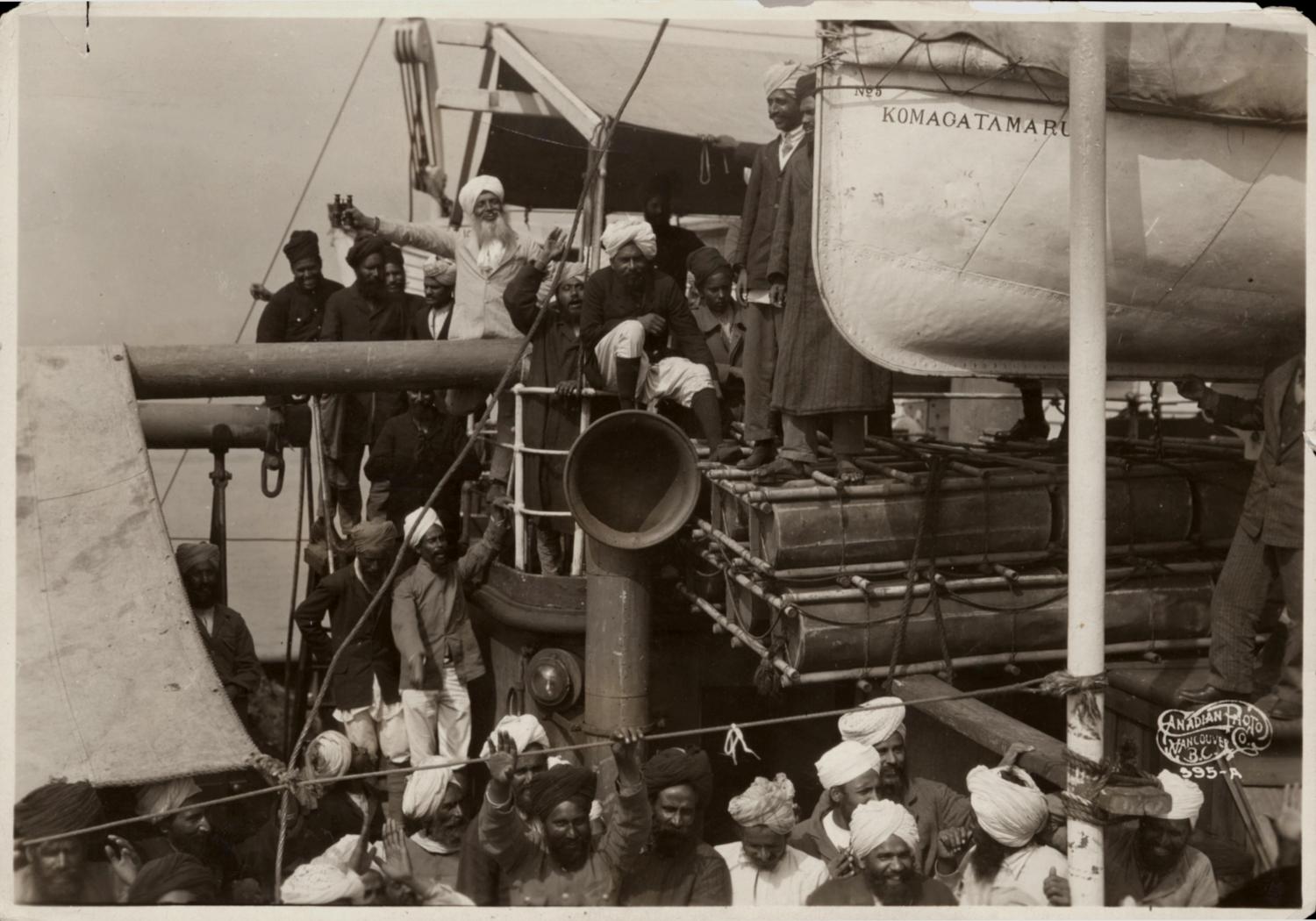 Sikh people aboard ship, 'Komagata Maru' - Gurdit Singh with white beard and light coloured suit