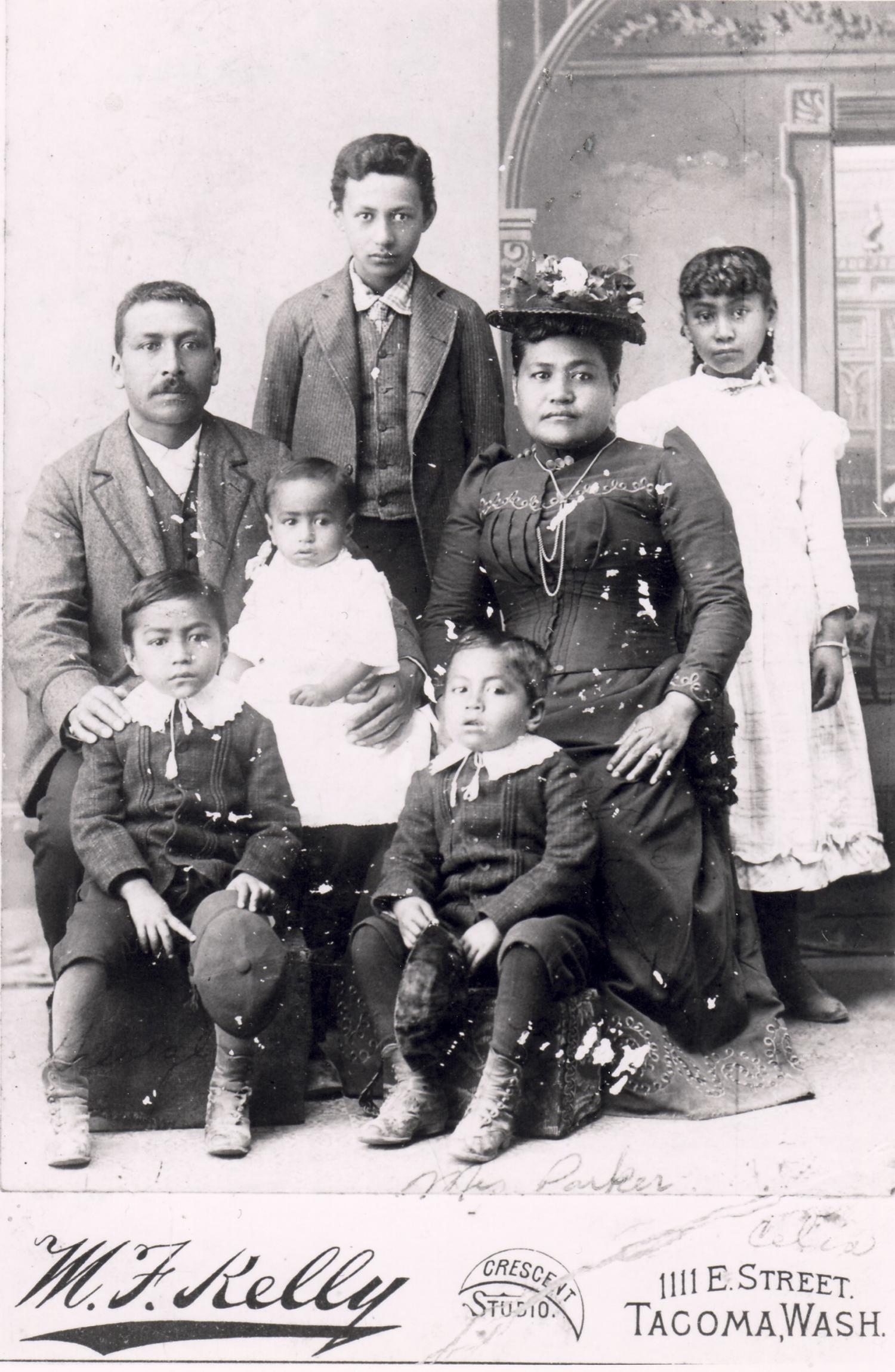 William Naukana's eldest daughter, Delia, in a studio portrait with her first husband, George Napoleon Parker, and children taken during an 1890 visit to Tacoma from the Gulf Islands.