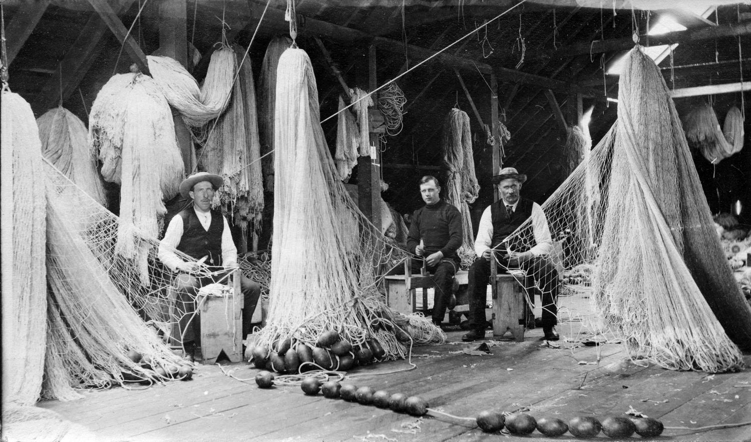North Pacific Cannery, showing men repairing fishing nets