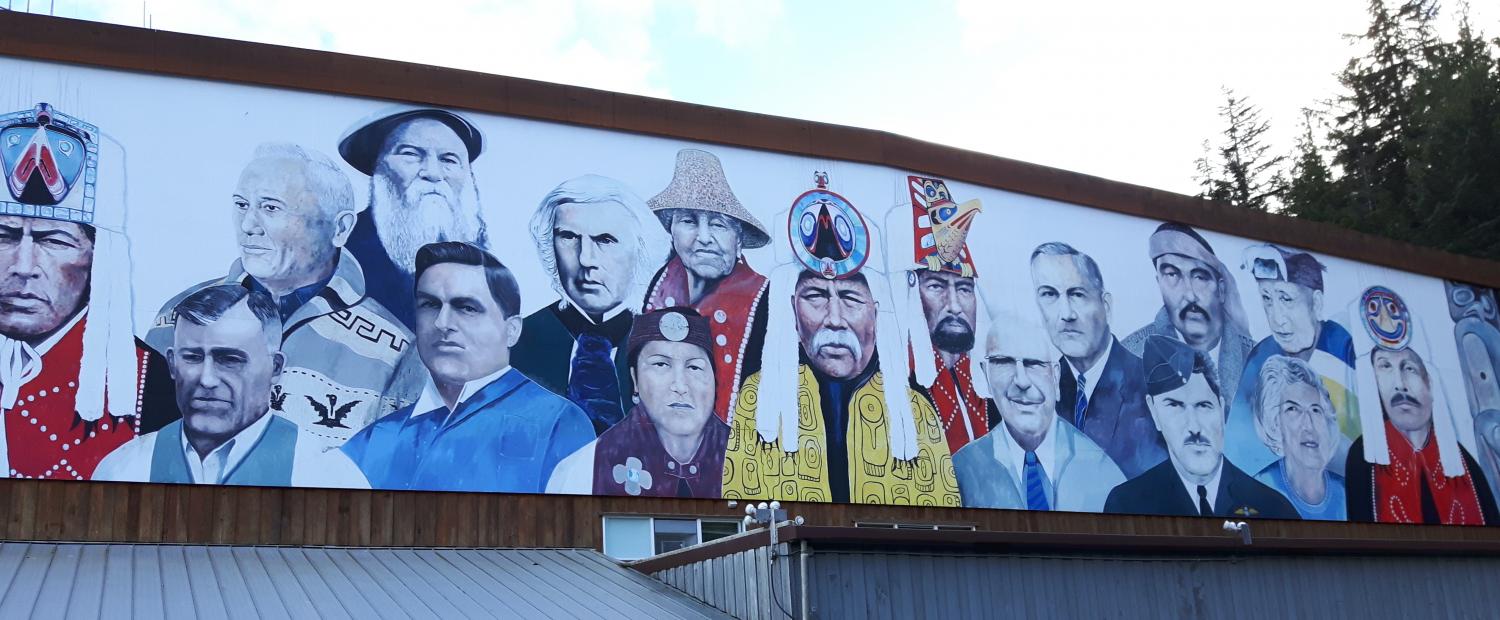 The mural features portraits of the four founding Chiefs of the Heiltsuk Nation in regalia, a portrait of the Hudson’s Bay factor John McLoughlin who established Fort McLoughlin at Bella Bella in 1833 and images of historic Heiltsuk and non-Aboriginal community members who made a significant contribution to the establishment of the greater Bella Bella community during the past 150 years.