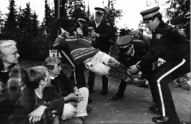 Police arrest Clayoquot Sound logging protesters, summer 1993. Person being lifted by 4 RCMP.