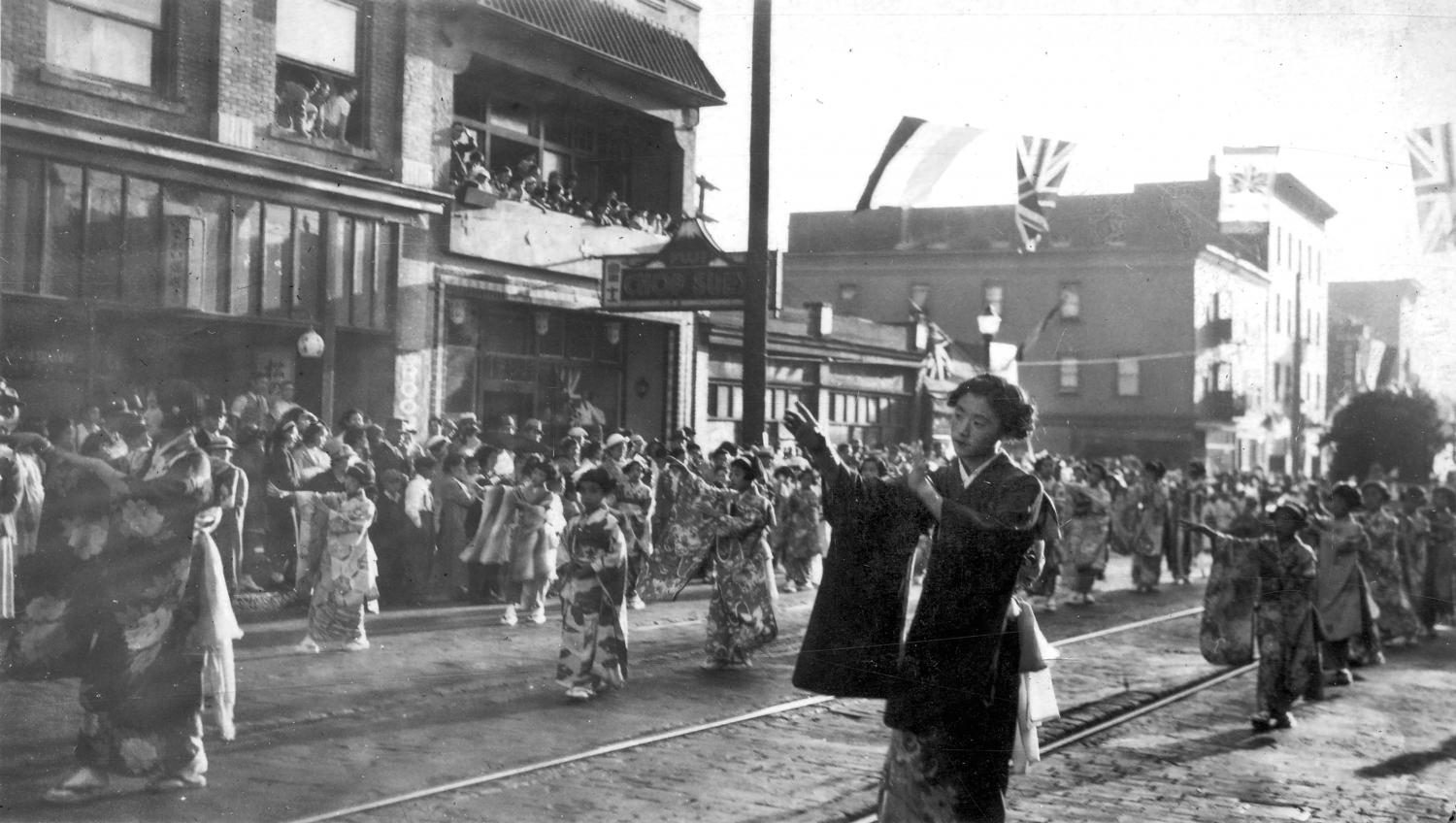Japanese women in traditional dress participate in a parade along Powell Street.