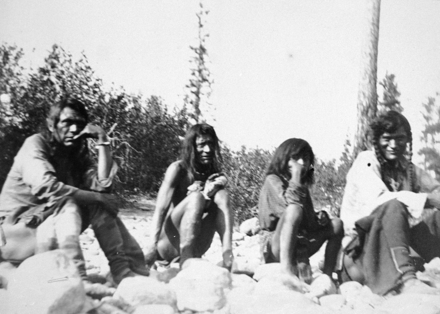Members of the Ktunaxa First Nation sitting on rocks