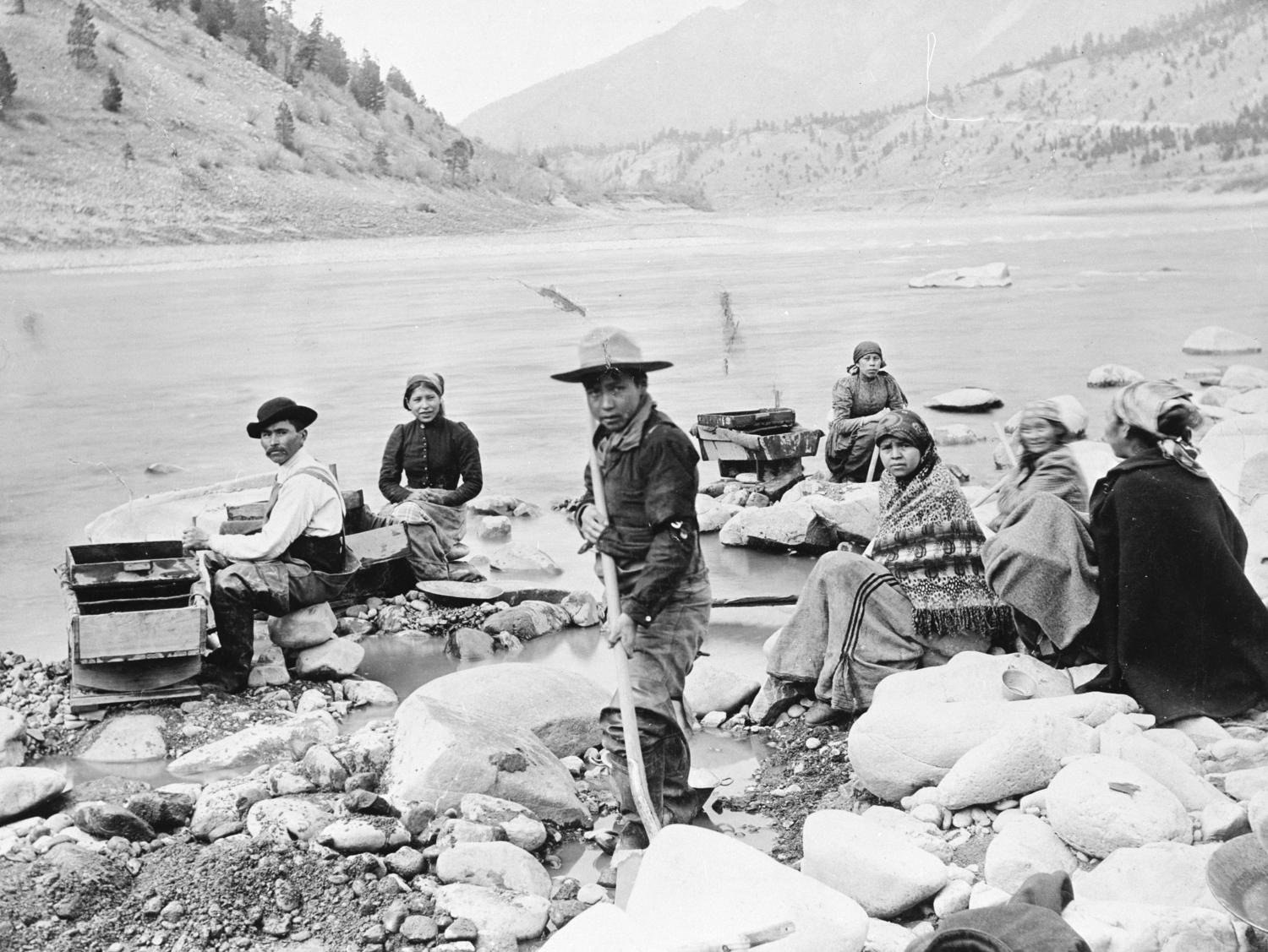 A First Nations family placer mining with sluice boxes and gold pans at the confluence of the Thompson and Fraser River near Lytton; Chief Charles Brown's mother is second from the [left]