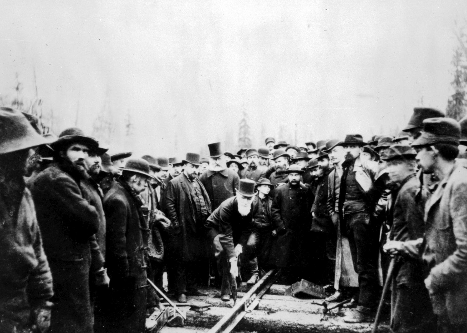 Photo of the last spike and Donald Smith, later Lord Strathcona, being surrounded by workers.